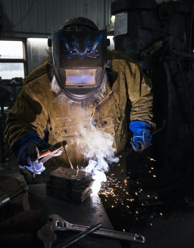 blacksmith-in-welding-mask-welding-metal-in-workshop.jpg